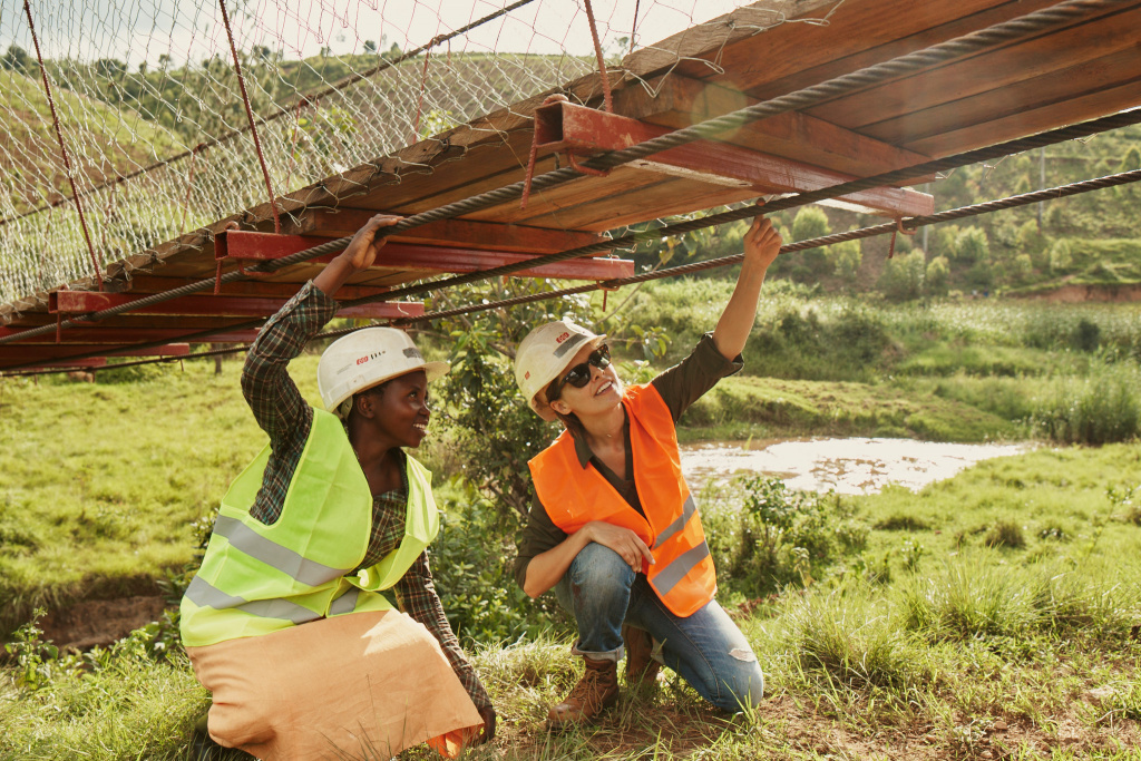 Bridges to Prosperity (B2P) входит в портфель Autodesk Foundation Health & Resilience. B2P работает с местными сообществами, партнерами и фондами над созданием пешеходных мостов, которые соединят жителей с образованием, здравоохранением и экономическими возможностями. Здесь инженеры осматривают кабели пешеходного моста B2P в Руанде. Изображение предоставлено Bridges to Prosperity.